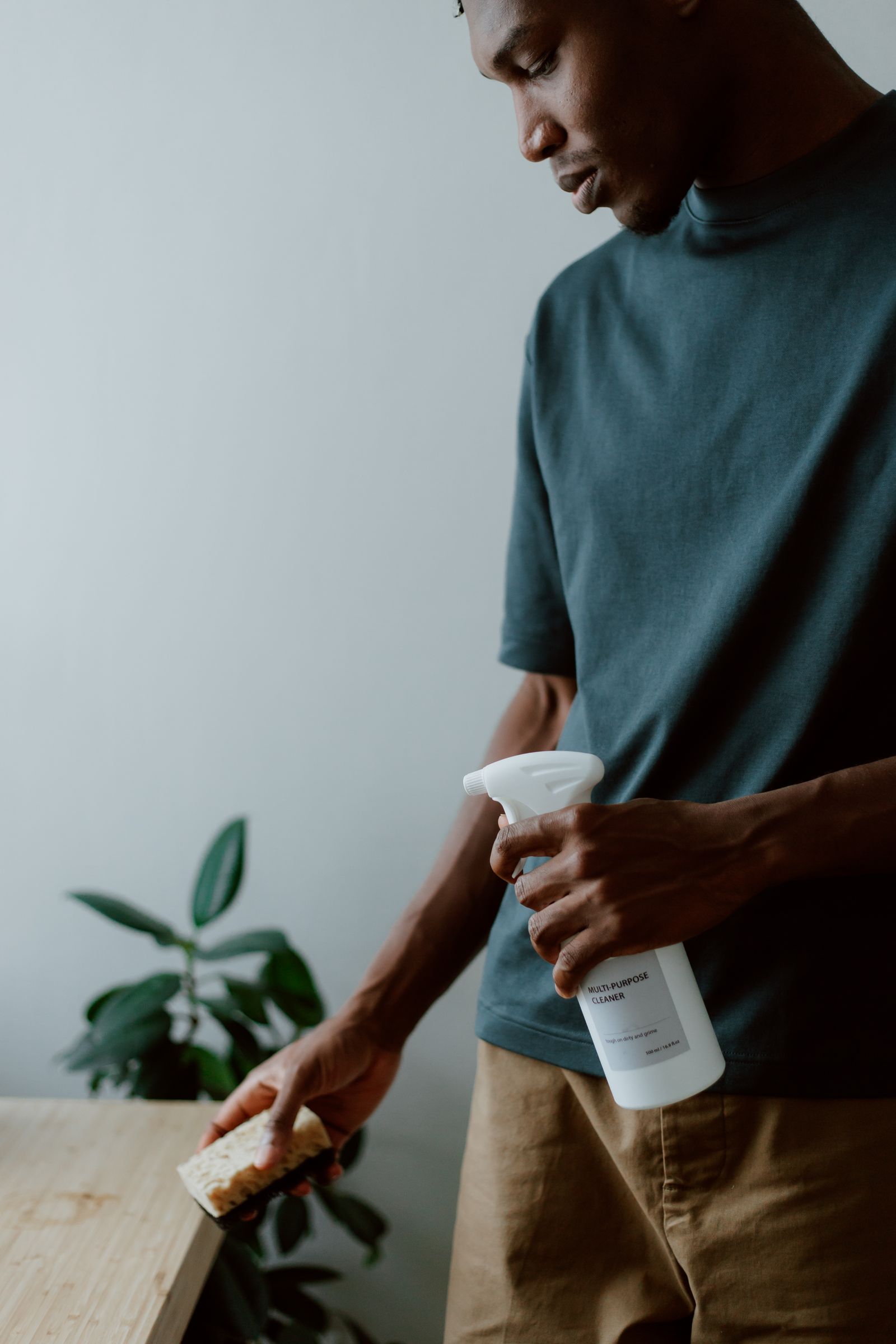 A man holding a cleaning spray and sponge