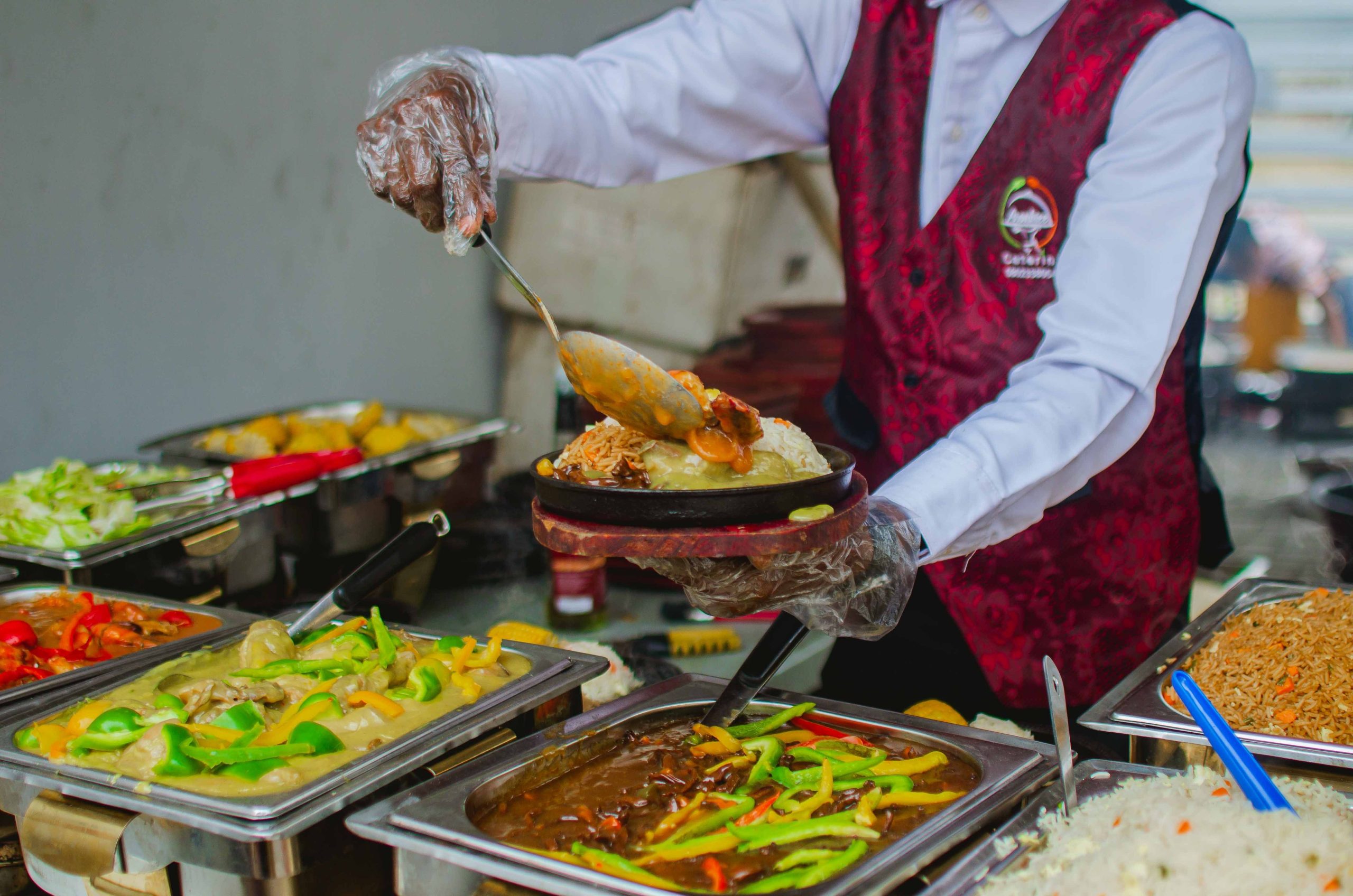 A chef serving food from a buffet counter