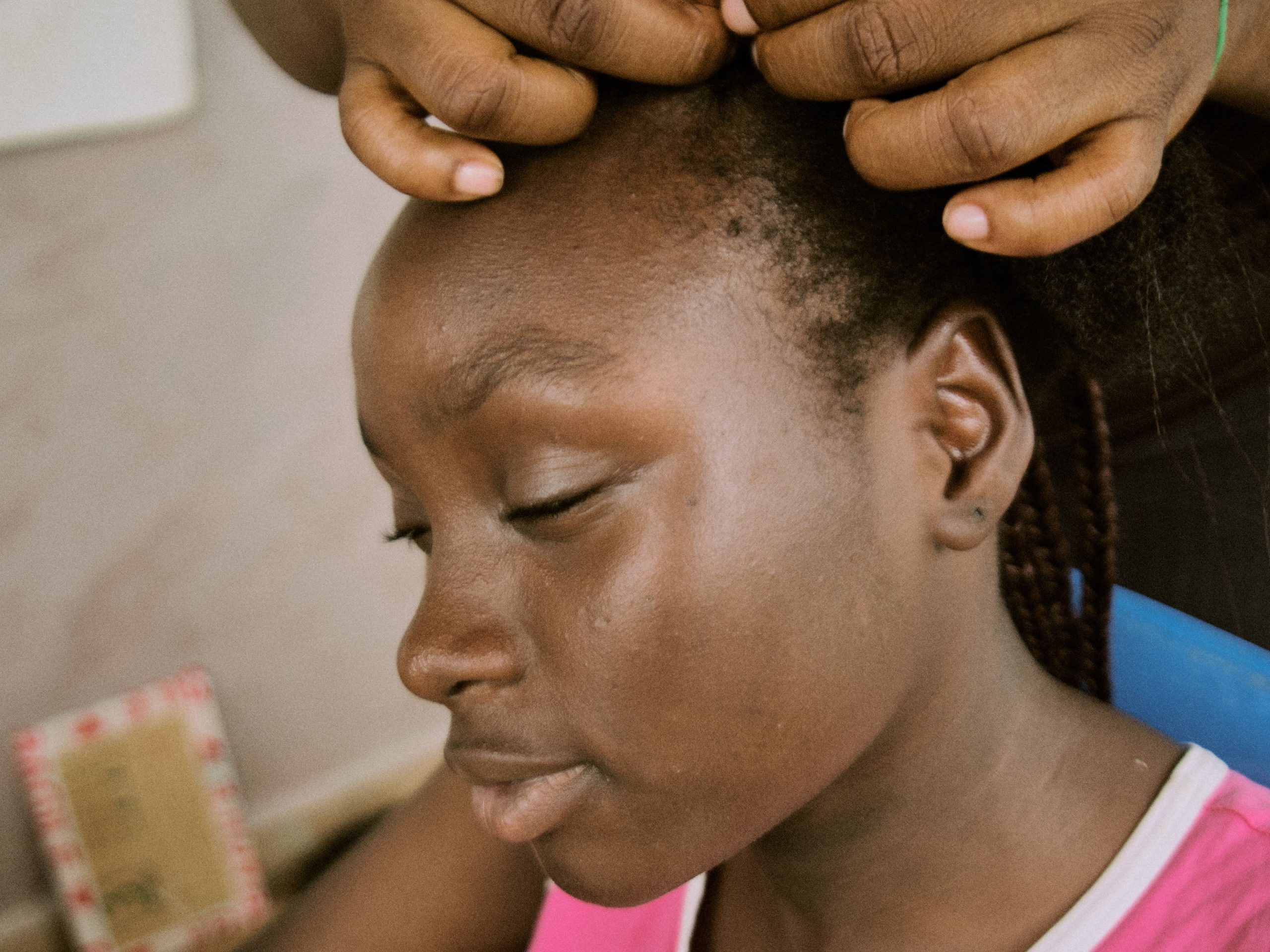 Hands styling braids in a young woman’s hair