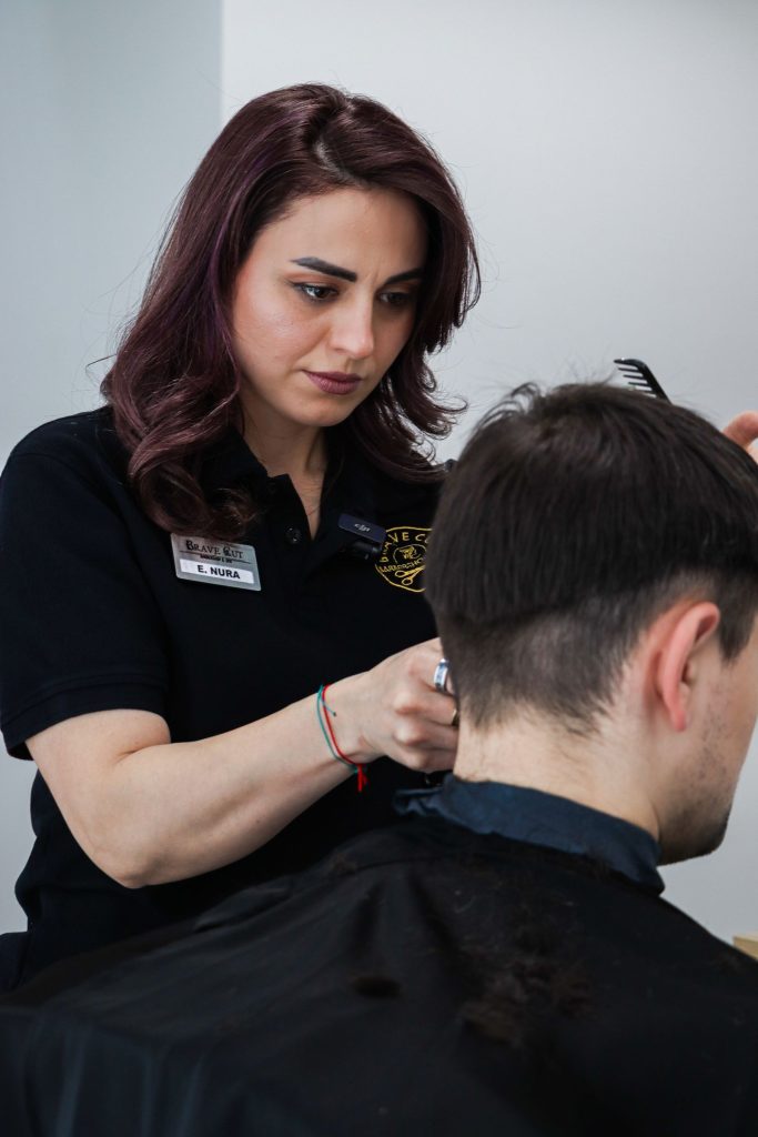 A hairdresser trimming a client’s hair