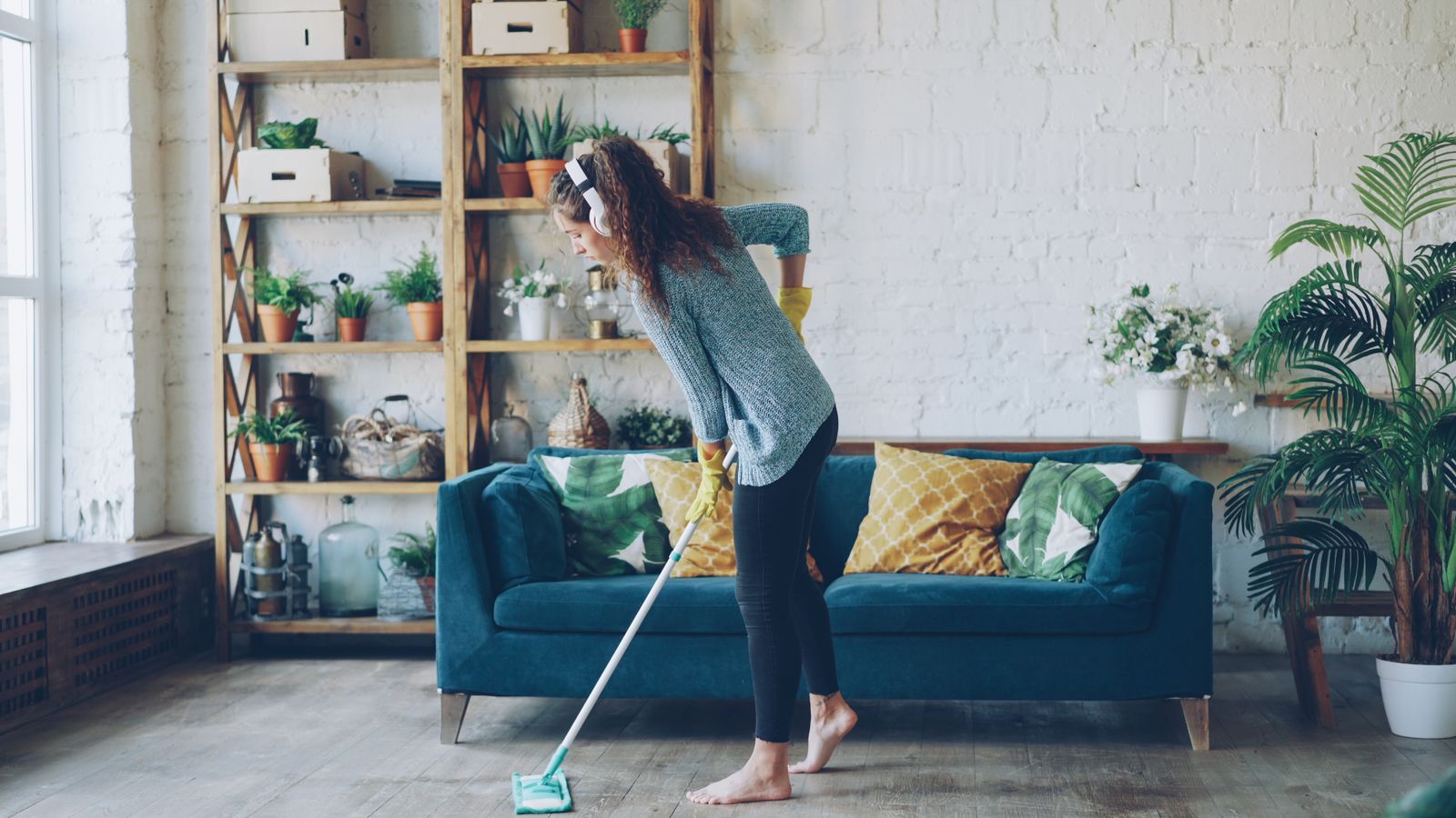 A woman cleaning the floor in a furnished living room