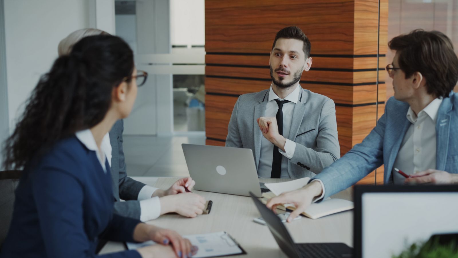 Three colleagues discussing documents around an office table