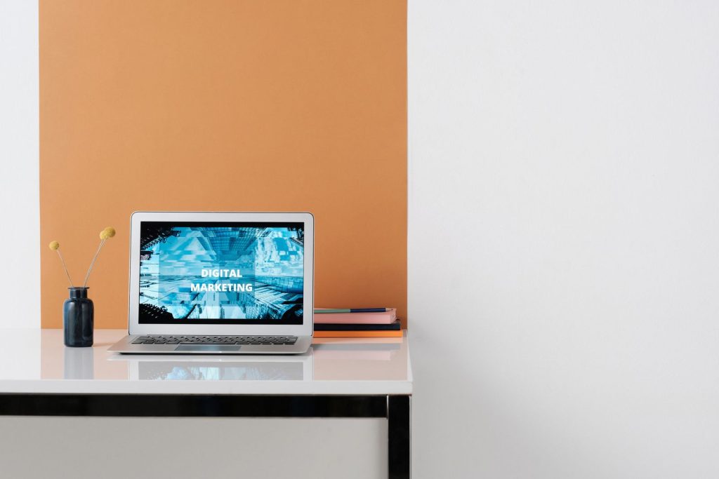 A laptop displaying a digital marketing graphic on a desk